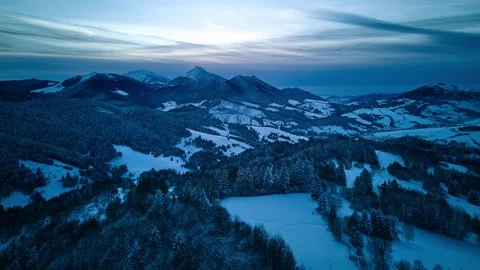 Aerial hyperlapse of winter mountain peaks at dusk with moving clouds and snow Stock Footage 336394844