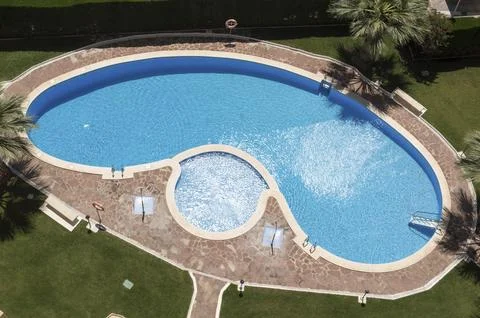 Aerial image of an irregular pool with a spa in the center Stock Photos