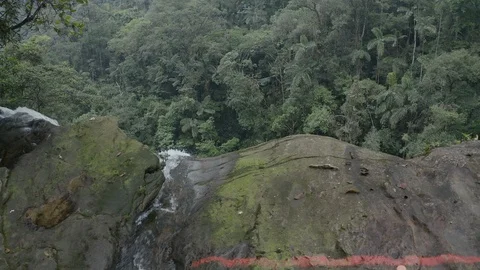 Aerial inches forward while tilting down to reveal the Fin del Mundo waterfall 스톡 동영상 104887088