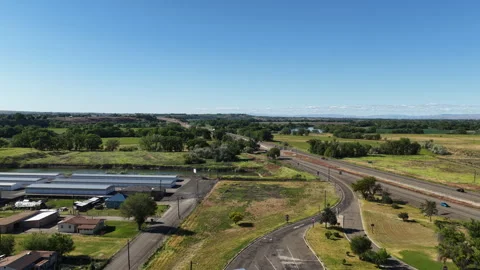Aerial of Interstate 84 through Ontario Oregon next to Snake River in spring Stock Footage 335779925