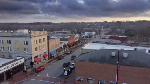 Aerial -  Jeep Drives Down Main Street Sunset over Small Town America Stock Footage 146705161