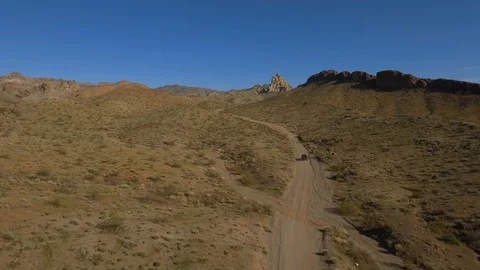 Aerial of a jeep on a rugged trail through desert mountains Stock Footage 123720789
