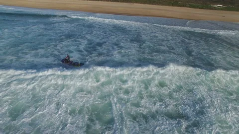 Aerial of jet ski capsize while rescuing pro surfer from ocean water in Nazare Stock Footage 159838857