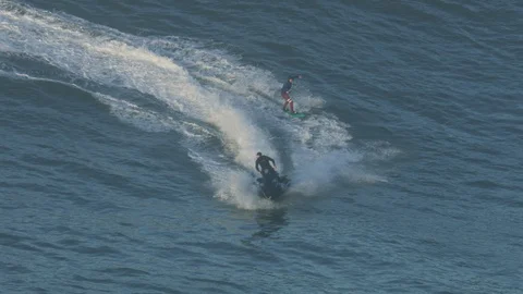 Aerial jet ski towing surfer on wave Mavericks Stock Footage 104262353