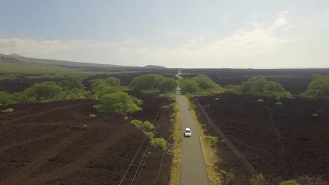Aerial Jib Down White Van traveling Down Desolate Lava Rock Road Stock Footage 95921927