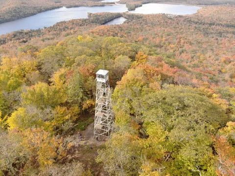 Aerial of Kane Mountain Fire Tower with autumn forest scape water near Fulton Co Stock Photos