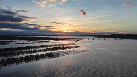 Aerial of lagoon bridge at sunset with dramatic clouds 4K Stock Footage 339864347