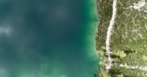 Aerial Lake, top down view of path next to shoreline of beautiful Alpine Lake Stock Footage 148533581