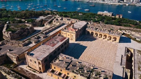 Aerial landscape mid angle drone shot panning around fort Manoel in summer with Stock Footage 335295946