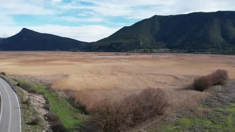 Aerial landscape of mountain plain with dry wetland and road Stock Footage 344096754