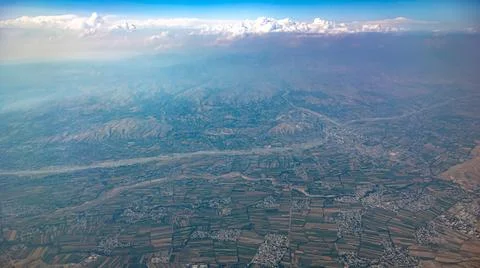 Aerial landscape showcasing vibrant fields, charming towns, and majestic moun Stock Photos