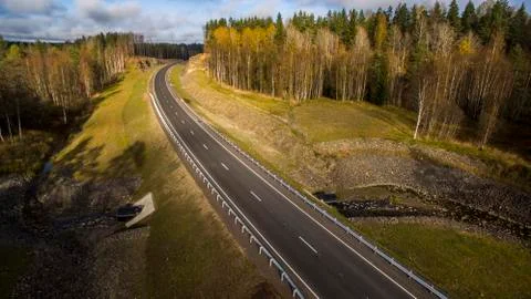 Aerial landscape view of empty rural road in beautiful autumn forest Stock Photos
