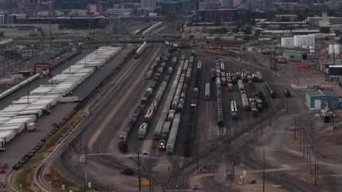Aerial of large active rail yard and industrial area tilt up to Denver view Vidéo 345341286