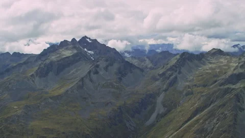 Aerial of large mountains with clouds in the distance Stock Footage 158523767