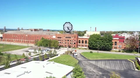 Aerial of a large old clock on the facade of an old abandoned vacant American Stock Footage 164449713