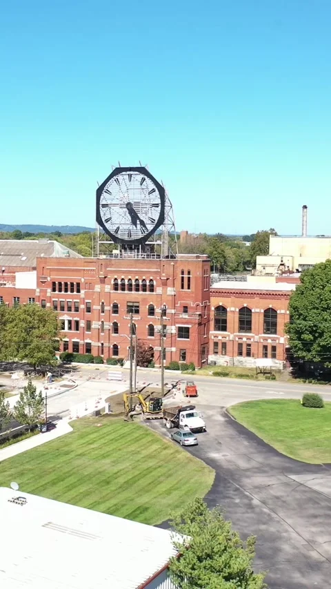 Aerial of a large old clock on the facade of an old abandoned vacant American Stock Footage 303985972