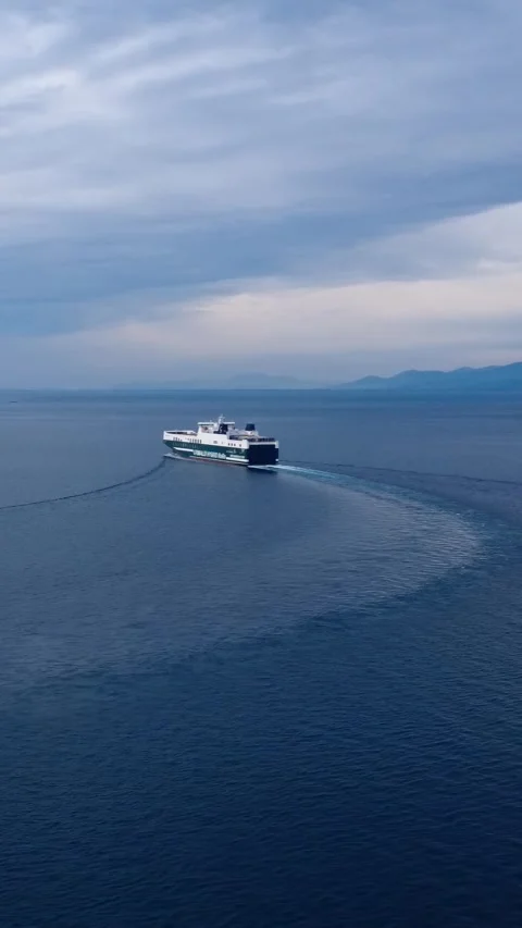 Aerial large ship sailing deep blue sea toward mountains horizon Stock Footage 343992285