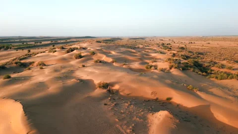 Aerial left arc shot over sand dunes during golden hour in Thar Desert Stock Footage 346772148