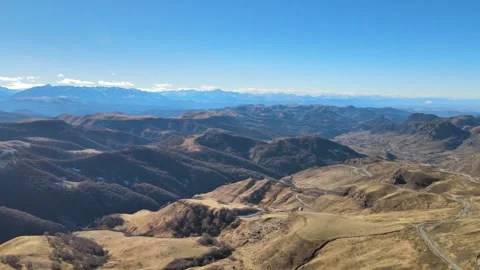 Aerial left-to-right pan of Gumbashi mountain pass scenic road and Caucasus ridg Stock Footage 337023788