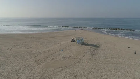 Aerial of Lifeguard Tower and Rescue Vehicle on Ocean Beach Under Sunny Blue Sky Stock Footage 210219853