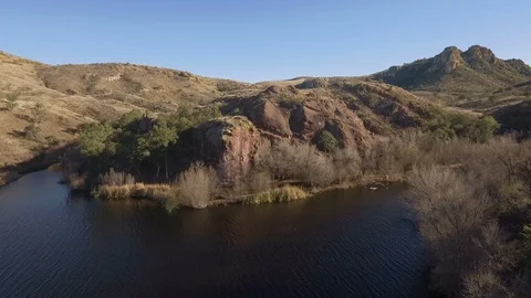 Aerial lift over cliffs on the side of a scenic lake Stock Footage 99757700