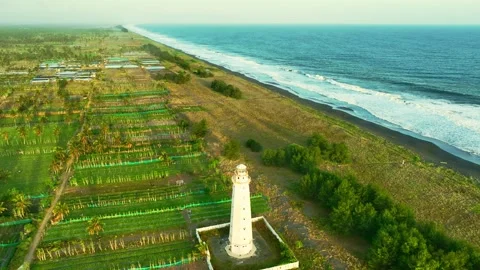 Aerial lighthouse view beside long ocean beach Stock Footage 335439368