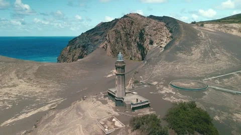 Aerial Lighthouse On Volcanic Ash Plain Overlooking Ocean. Stock Footage 323550292