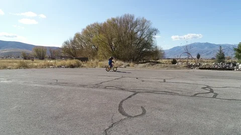 Aerial of little boy practicing to ride his tiny bike Stock Footage 98016884