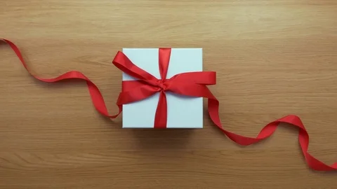 Aerial lockdown footage of woman opening red ribbon on gift Video stock 79651653