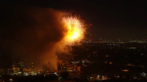 Aerial Lockdown Shot Of Fireworks Exploding In Illuminated City At Night - Los Stock Footage 169490582
