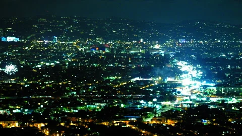 Aerial Lockdown Shot Of Fireworks Igniting Over Illuminated Buildings In Stock Footage 255412056