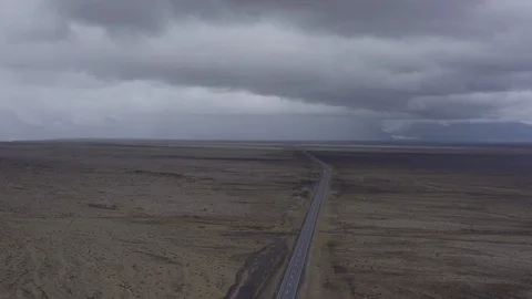 Aerial lockdown shot of vehicles moving on highway amidst landscape against Stock Footage 129437511