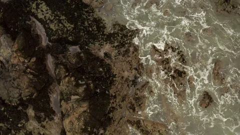 Aerial lockdown shot of waves splashing on rock formation in sea, drone flying Stock Footage 129432143