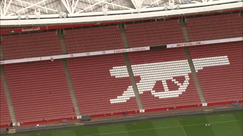 Aerial London - CU of gun logo on seating area of Arsenal Emirates Stadium Stock Footage