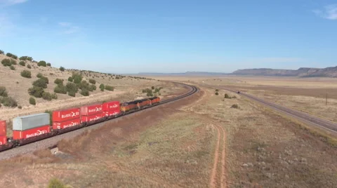 AERIAL: Long container freight train transporting goods across the country Stock Footage 62332105