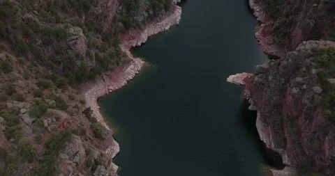 Aerial look down on the Green River in Flaming Gorge with colorful red cliffs Stock Footage 334734622