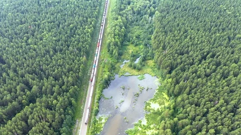 Aerial look-down shot.Camera fly over and crossing railways with passing train Video stock 112949857