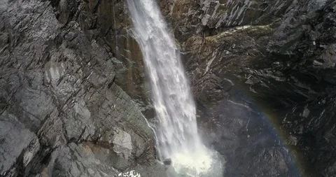 Aerial looking down and backing away from huge waterfall with rainbow Stock Footage 111352827