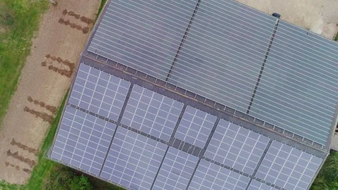 Aerial looking down at a big array of solar panels on a agricultural building Stock Footage 108035539