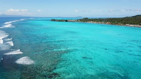 Aerial looking down at huge blue lagoon and waves crashing on reef 스톡 동영상 107035467