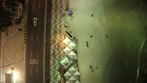 Aerial looking down over Copacabana beach at night ocean waves lapping at the 스톡 동영상 101287816