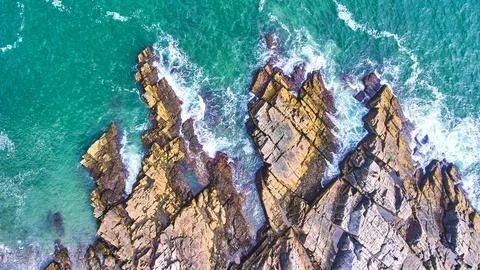 Aerial looking down on patch of rocky coasts in Maine with crashing waves 스톡 사진