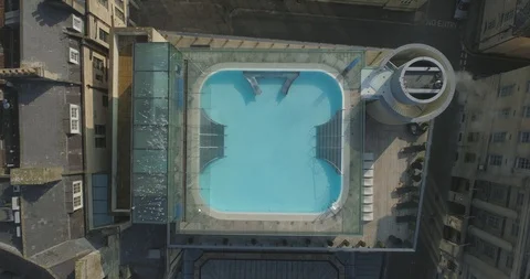 Aerial looking down rising up from rooftop pool in historic Roman city of Bath 스톡 동영상 108040205
