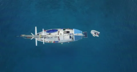 Aerial looking down as sailboat passes by closely underneath Stock Footage 65827007