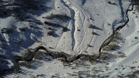 Aerial-Looking down snowy mountain road and stream rotating Stock Footage 71966907