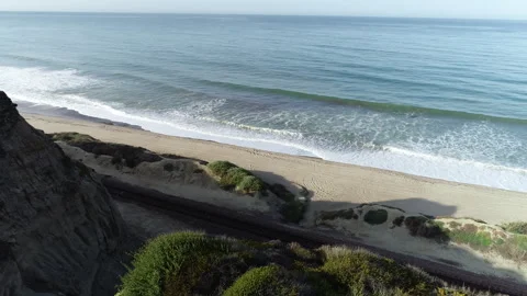 Aerial looking over bluff at the ocean Stock Footage 260445608