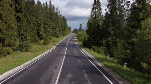 Aerial low air flight over mountain perfect asphalt highway road and meadow at Stock Footage 141979989