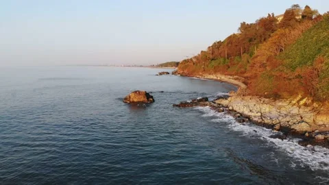 Aerial low angle panning view beautiful rocky beach in autumn with crashing w Stock Footage 188022290