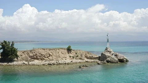 Aerial low angle shot of small lighthouse on small island in the sea. Stock Footage 132609821