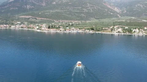 Aerial low angle shot of speedboat approaching Greek island village Stock Footage 343944434